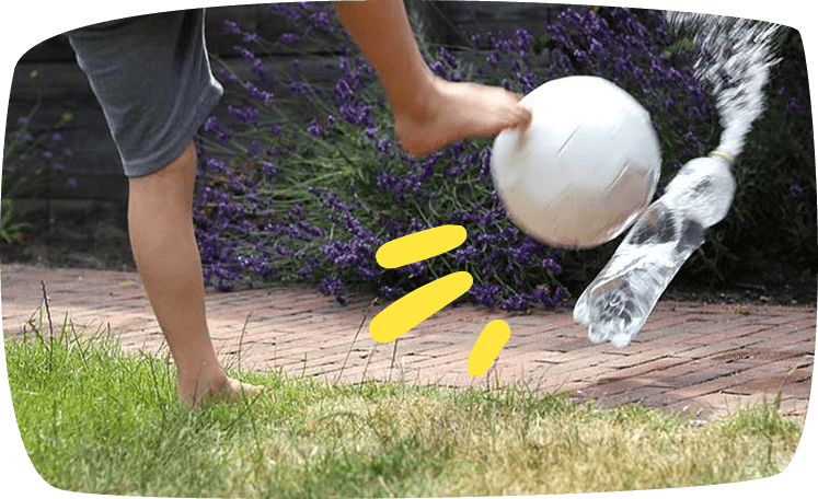 enfants jouant au foot avec des bouteilles d’eau debout comme cibles
